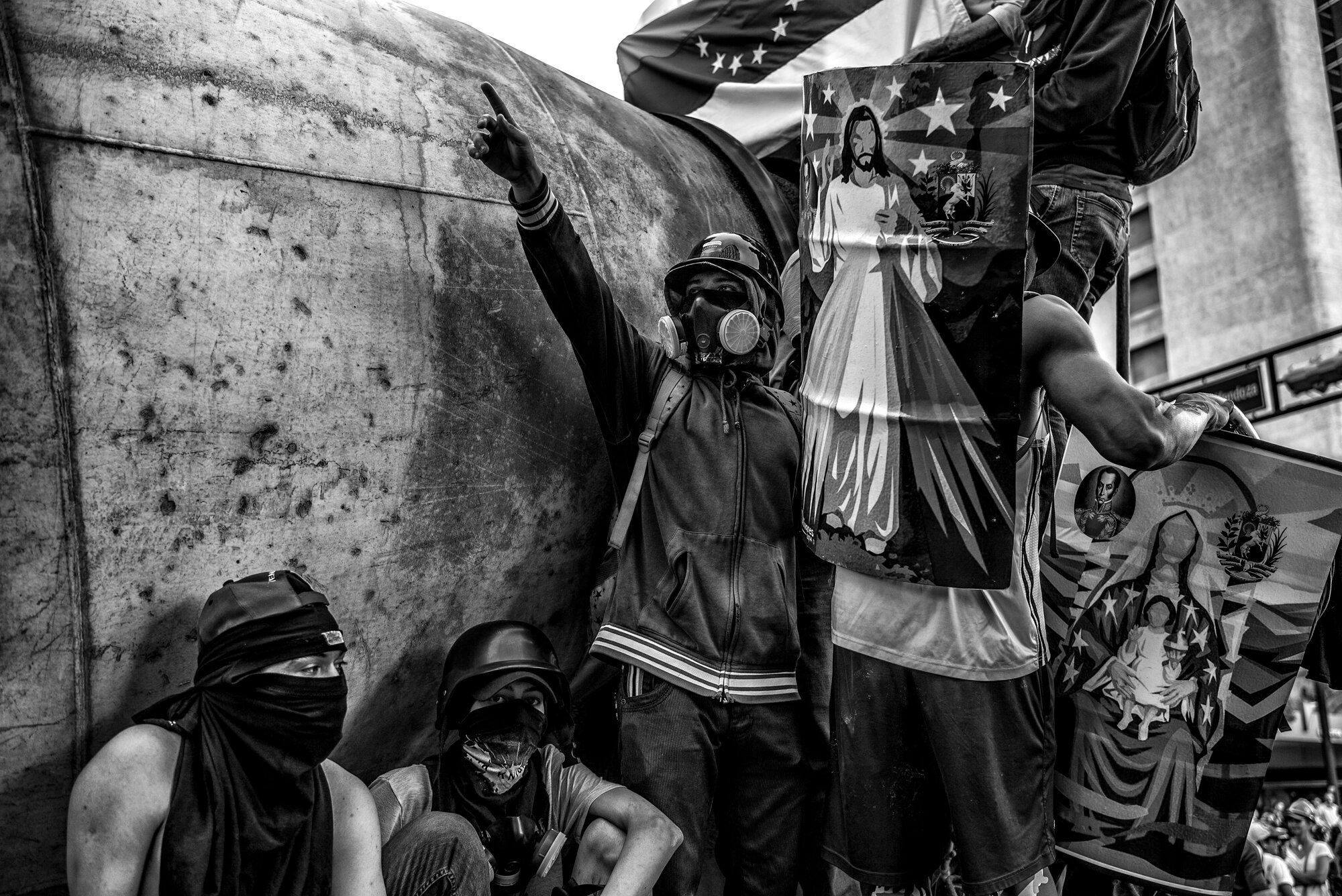 A black and white photo of four people in masks and street-style clothing.