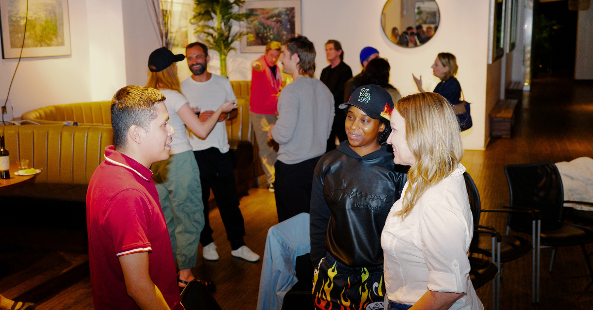Attendees networking at a branding event, with small groups engaged in conversation in a casual indoor setting.