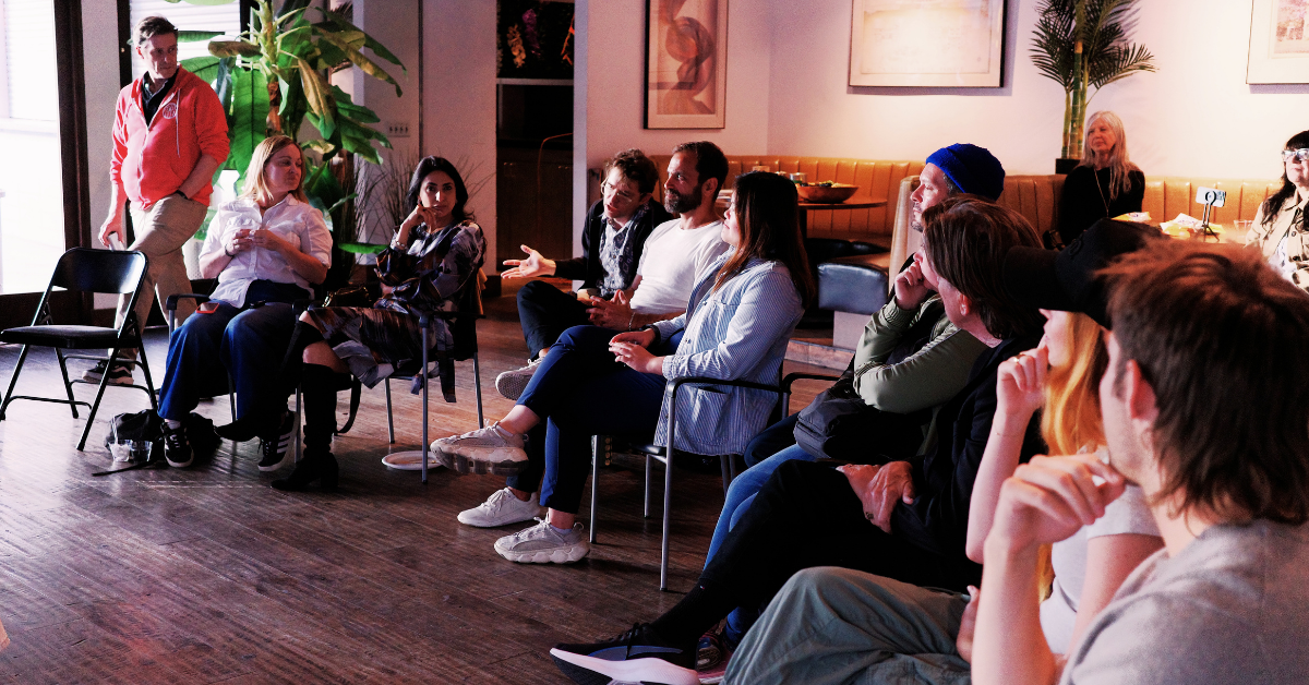 Group discussion during a branding workshop, with attendees seated in a circle actively engaging in conversation in a casual meeting space.