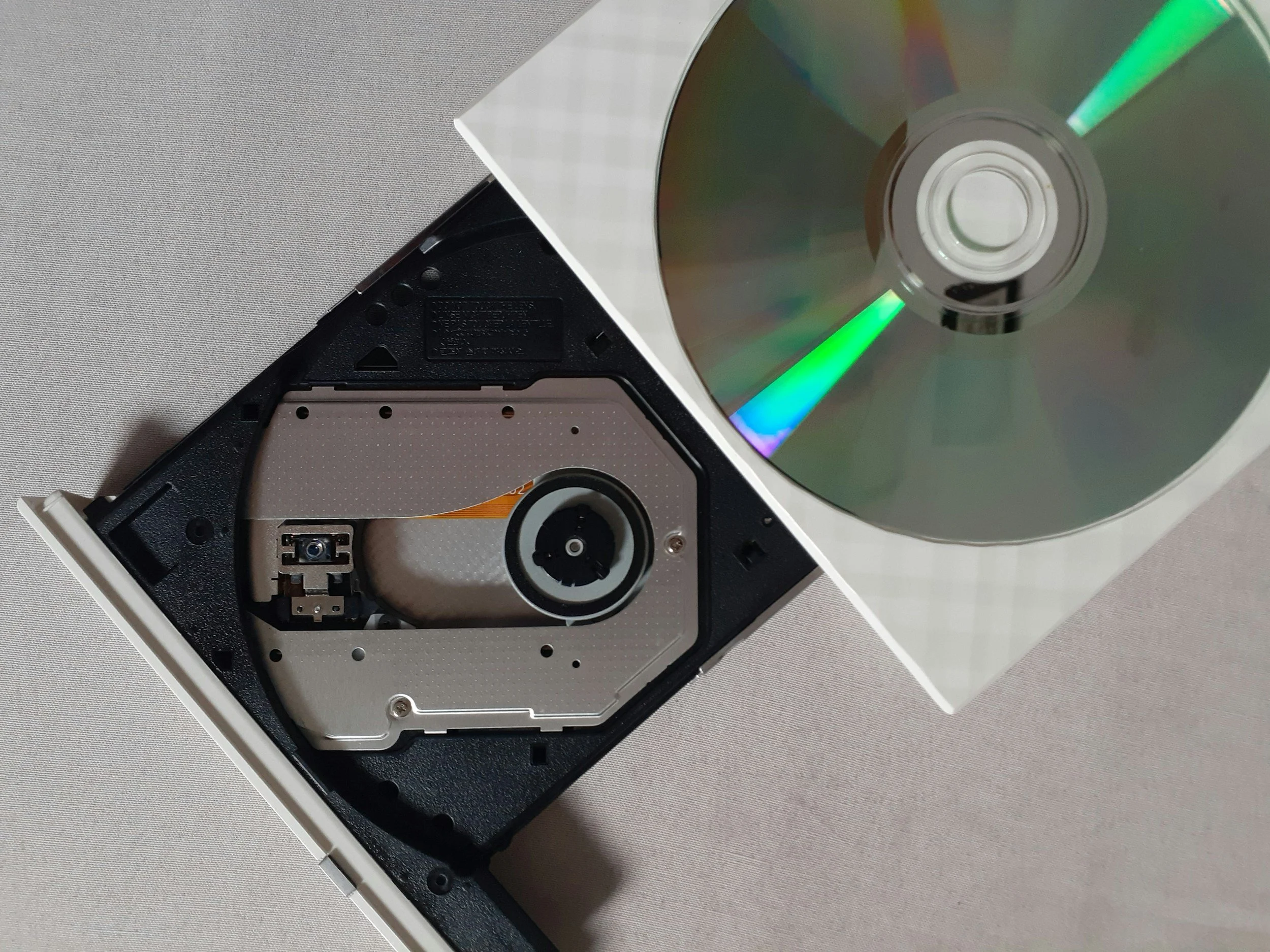Open computer hard drive with disc case and an opened DVD ready to be digitized by Nobles Imaging Lab, Hingham, MA
