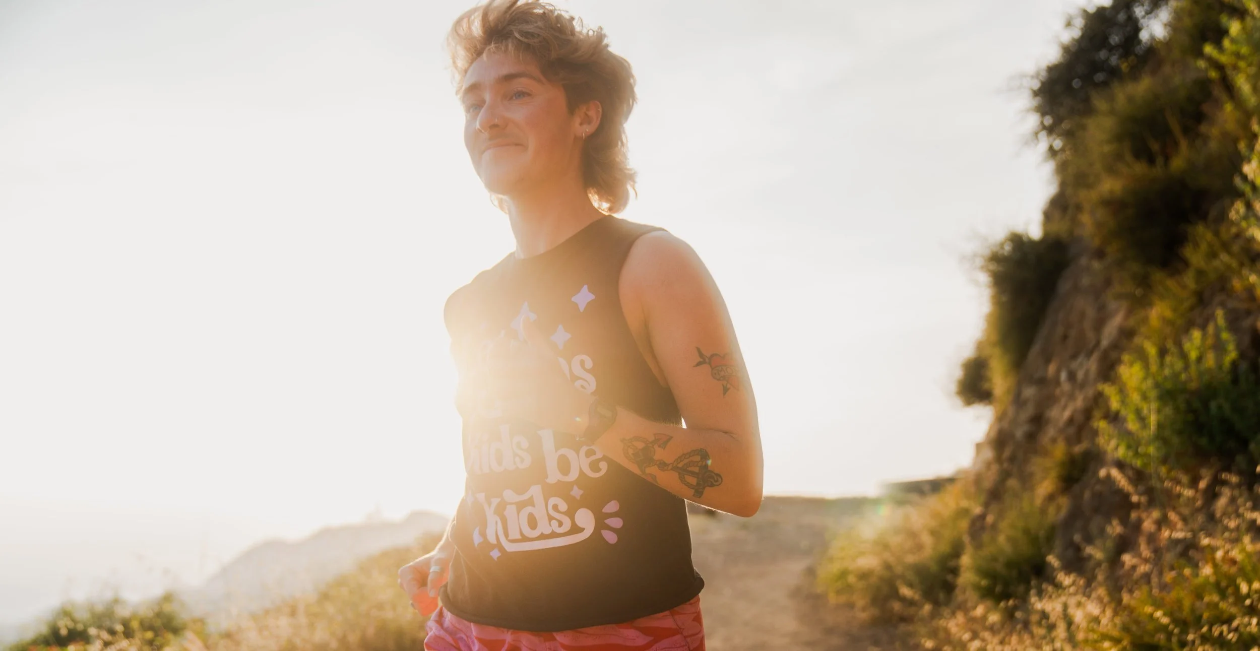 A blonde person running on a trail