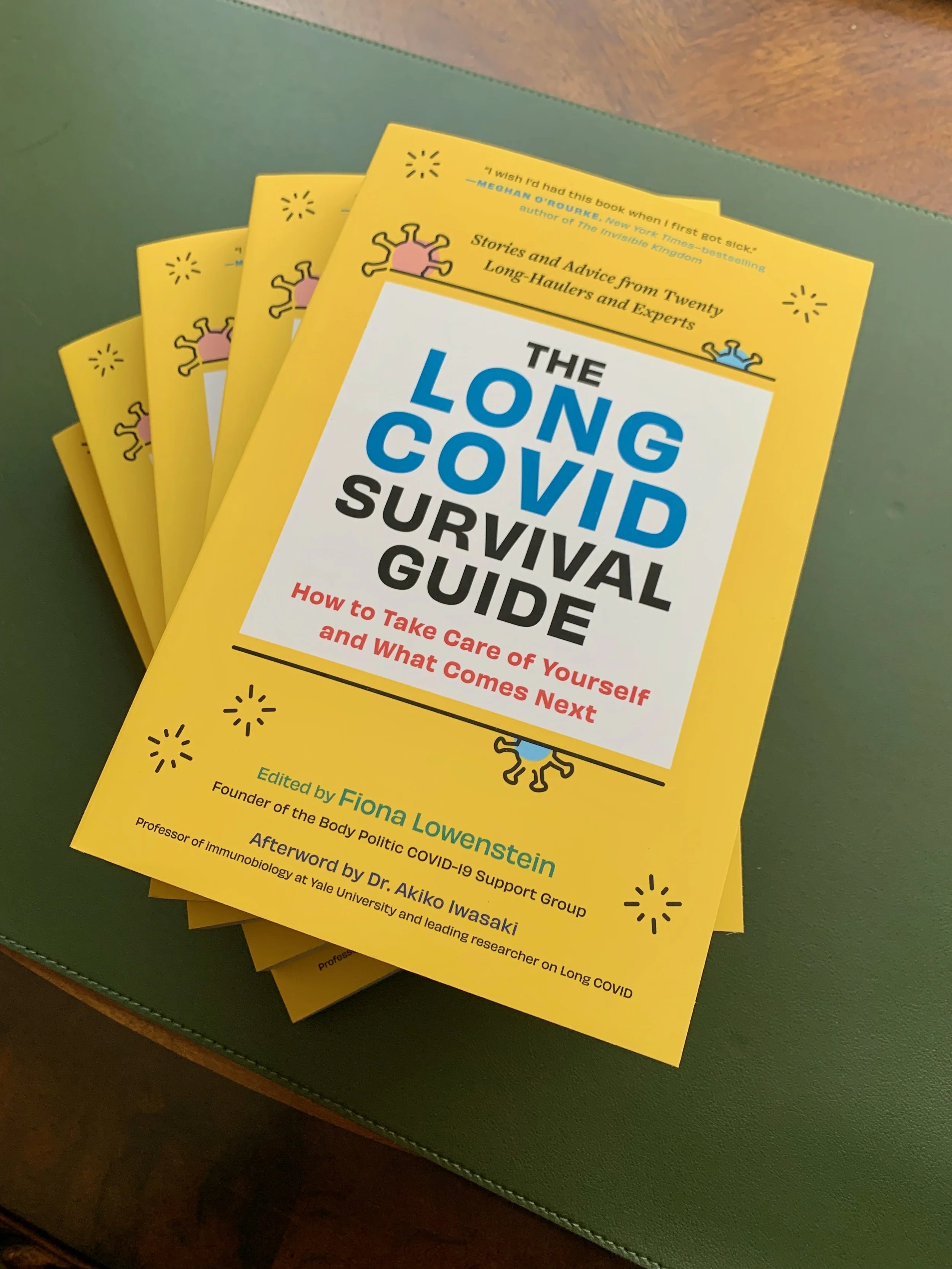 A stack of books with yellow covers. The text reads "The Long COVID Survival Guide"