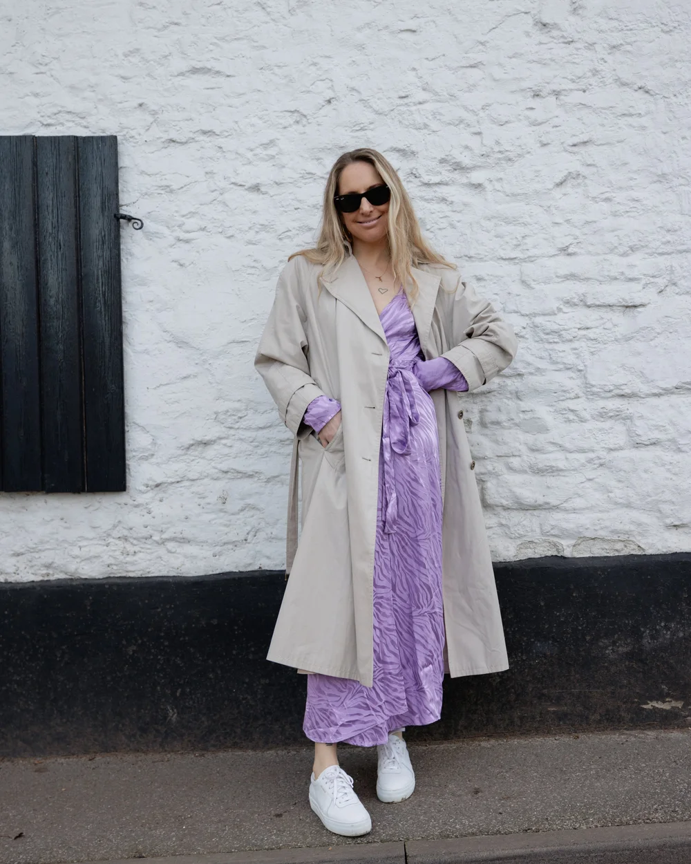 Beige trench coat worn over lilac dress on Abbie