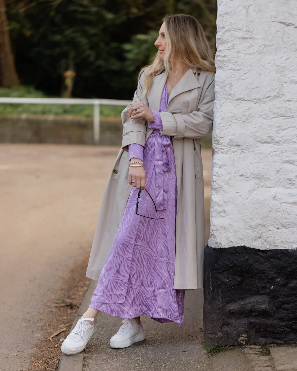 Beige trench coat worn over lilac dress on Abbie