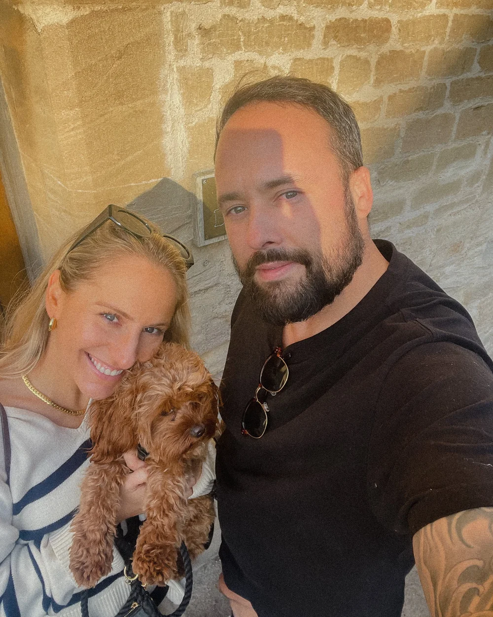 Abbie and her husband Matt cuddling their dog
