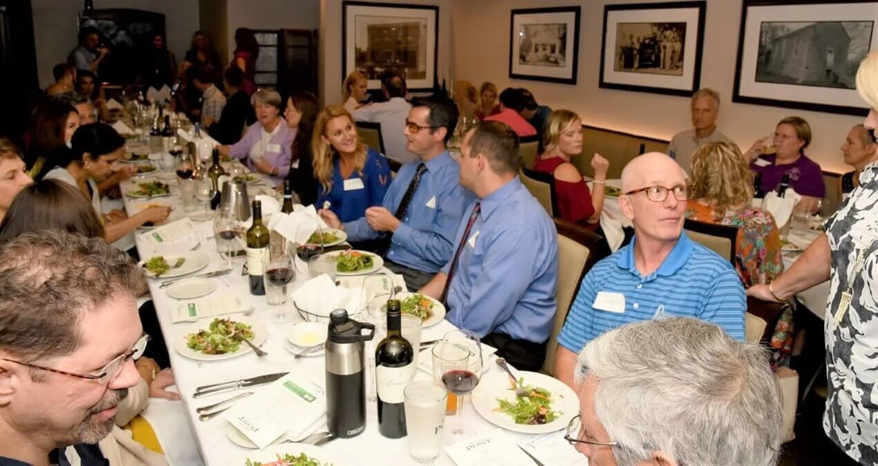 A group of functional medicine doctors and practitioners network at a SLiiM dinner event.