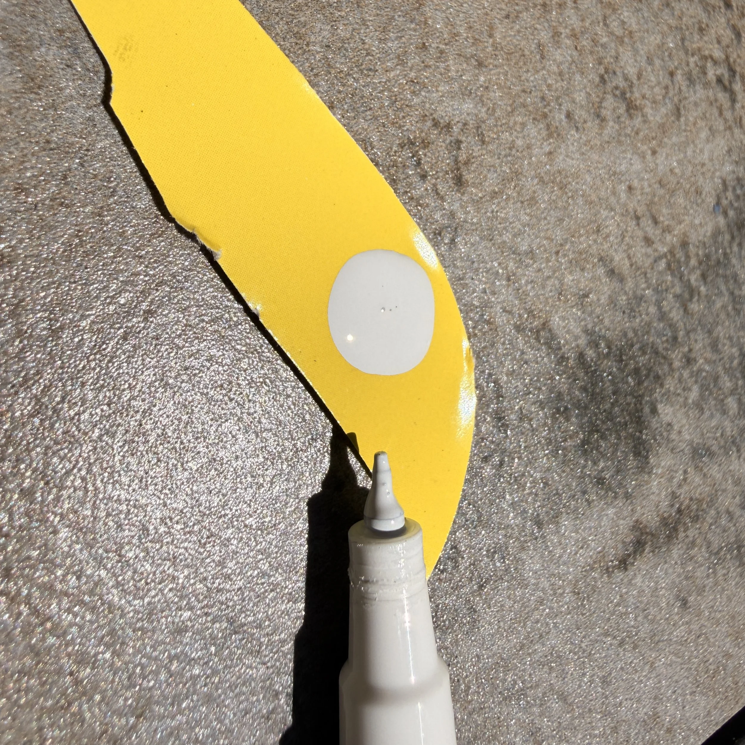 Prime your paint pen on a separate surface to avoid making a mess on your optic!