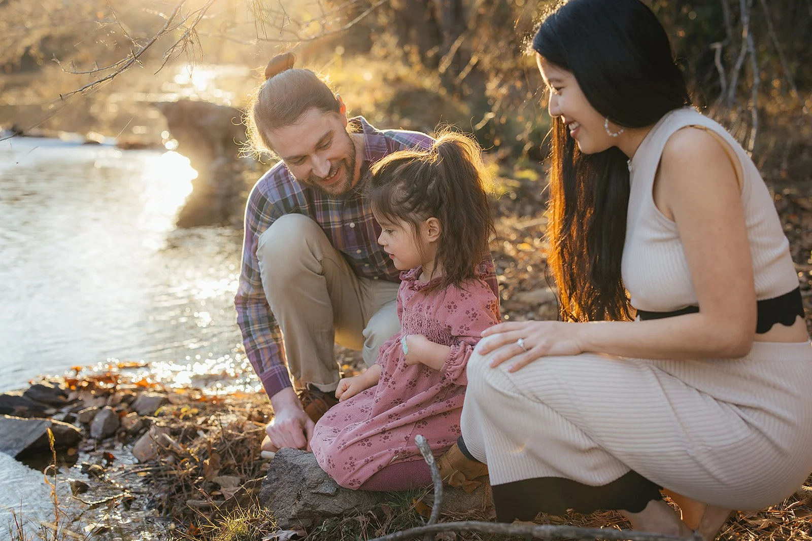 A family of three enjoys the river at a family photoshoot in Durham, NC