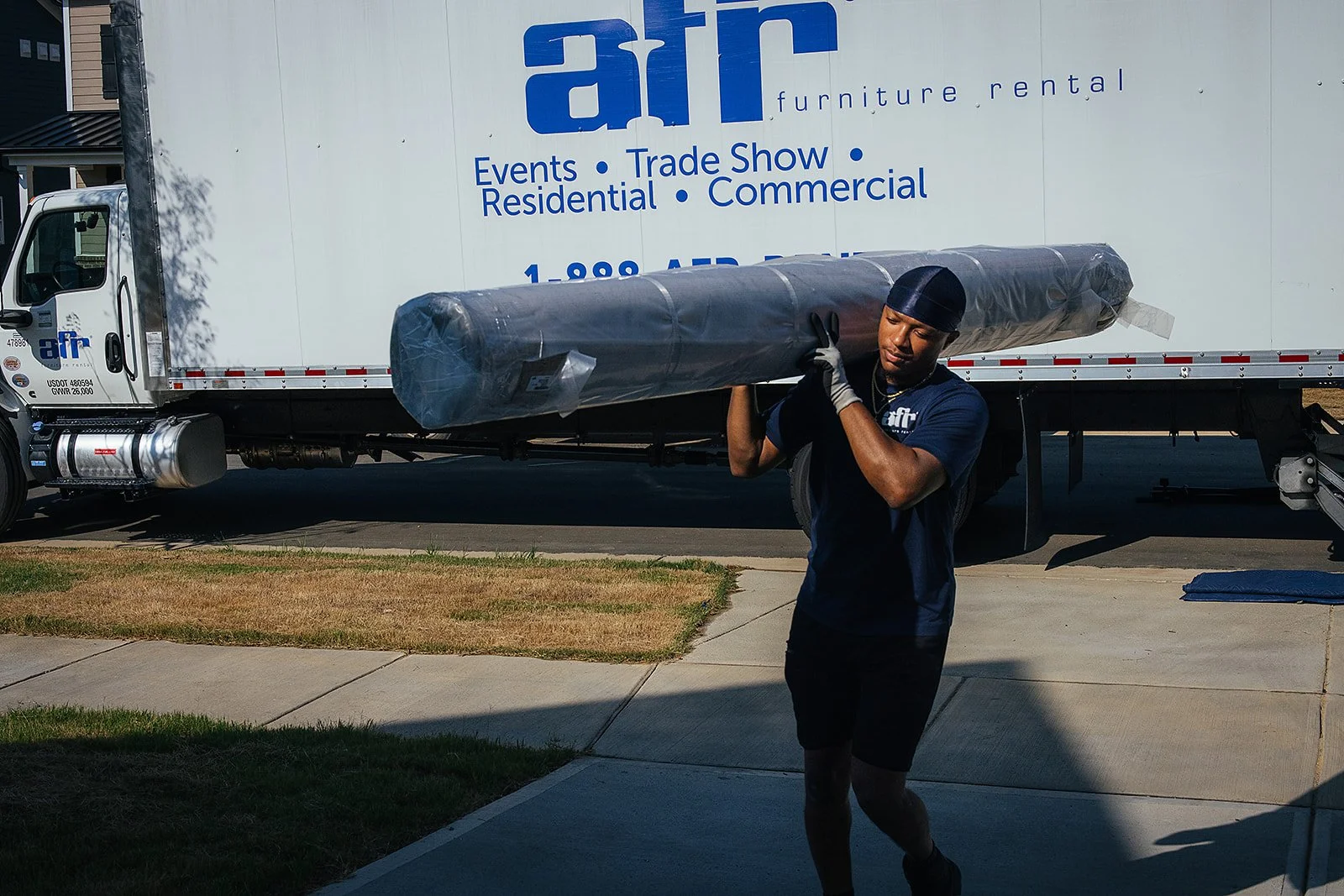 AFR Furniture Rental team moving furniture into a Durham home during a commercial photography session