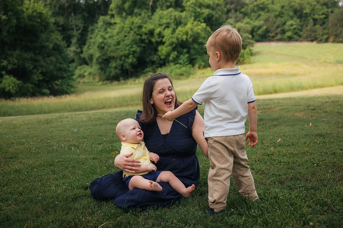 Mother holding her child near the trees at Blackwood Farm Park family session