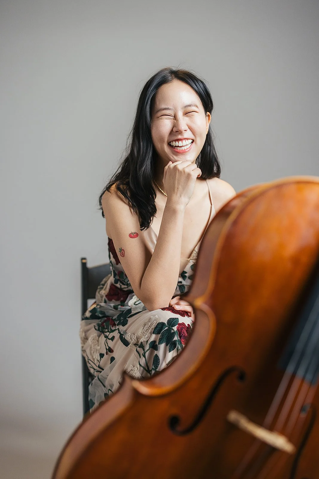 Woman Smiling With Elbow on Cello