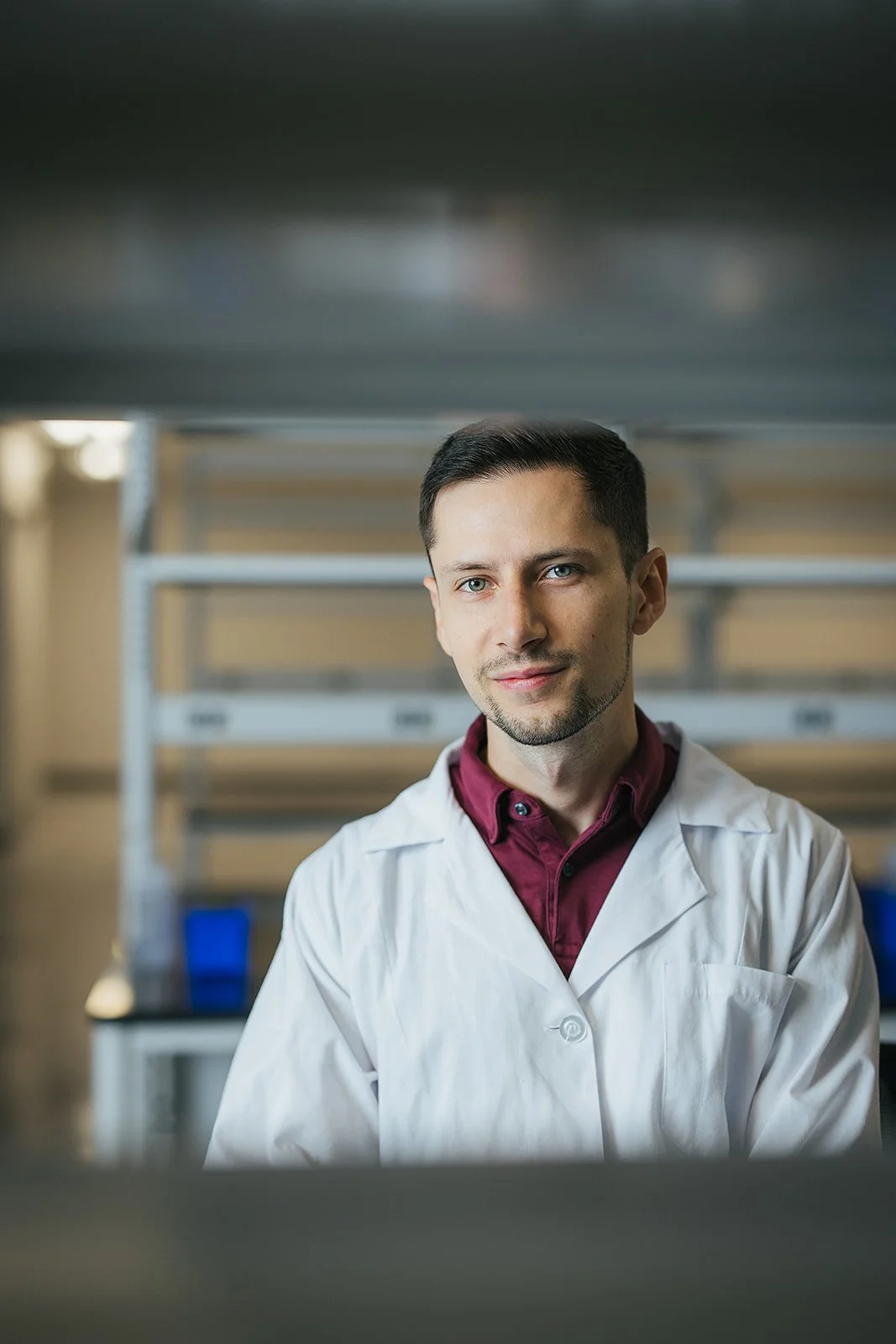 ManInWhiteLabCoatAndRedShirtSmiling