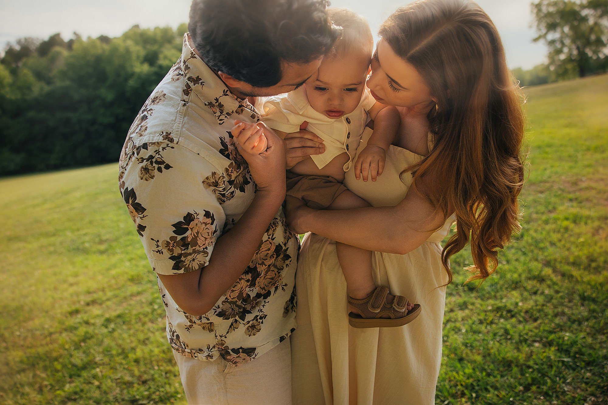 Parents Snuggling Toddler in Golden Light Durham NC