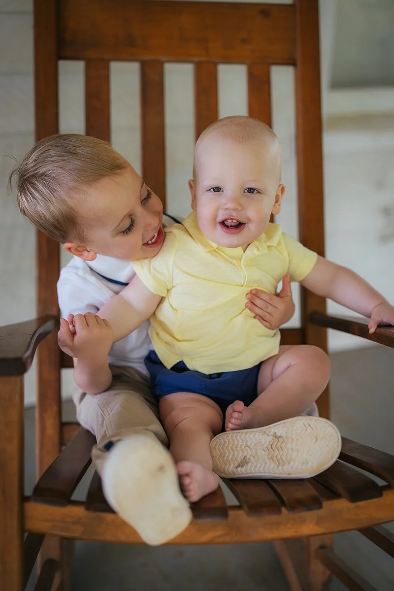 Siblings sitting together on rocking chair
