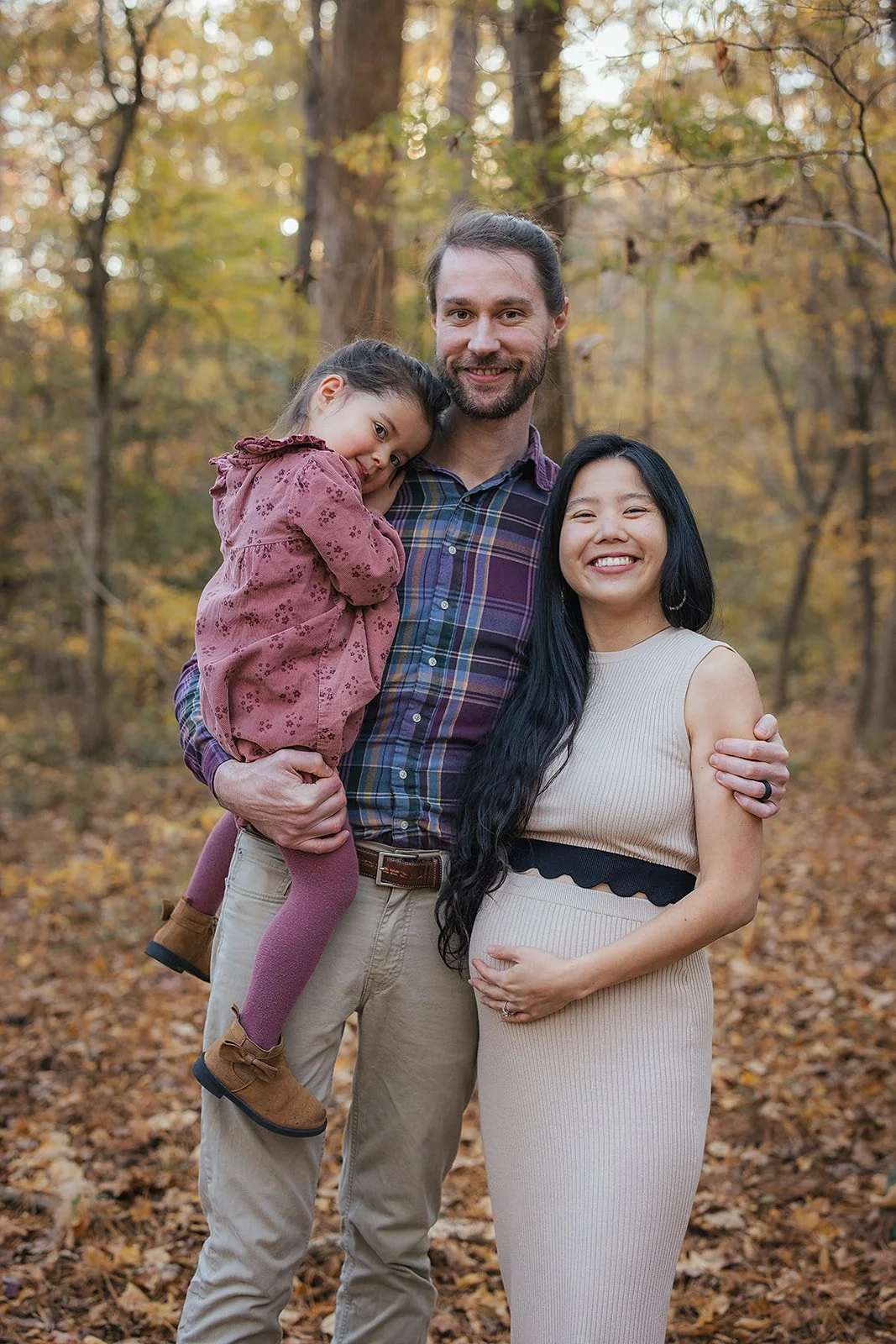 a family poses for family photos at the Eno River in Durham, NC