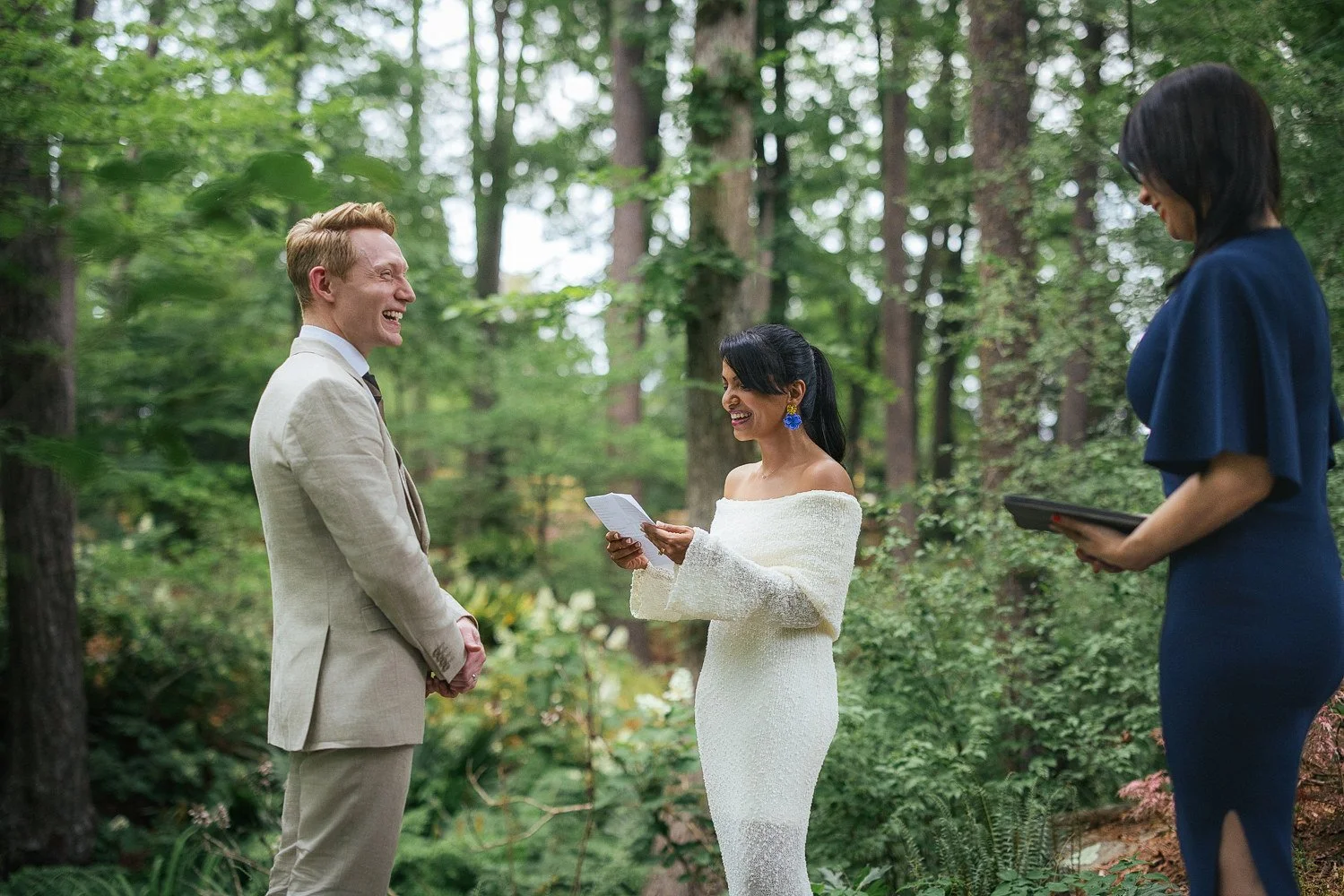 Couple smiles while reading vows during a vow renewal ceremony at Duke Gardens in Durham, NC