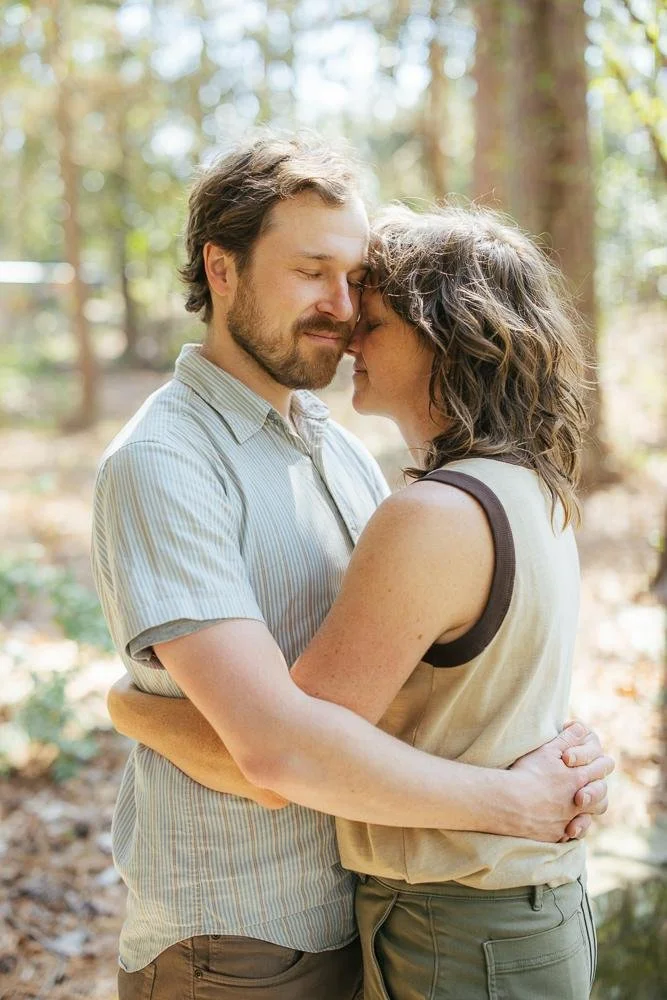 Mom and dad in an intimate couple portrait nearly nose to nose in the forested section of Duke Gardens Durham NC