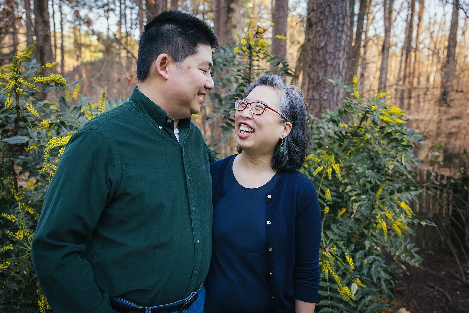 Parents smiling outside in front of trees family portrait session