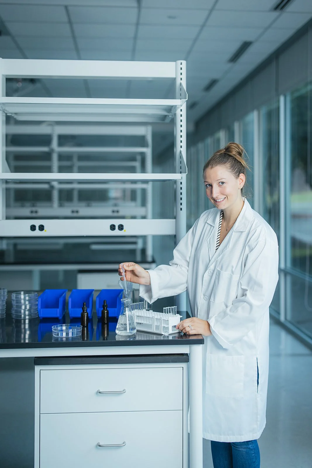 WomanSmilingInWhiteLabCoatInLabInRTP