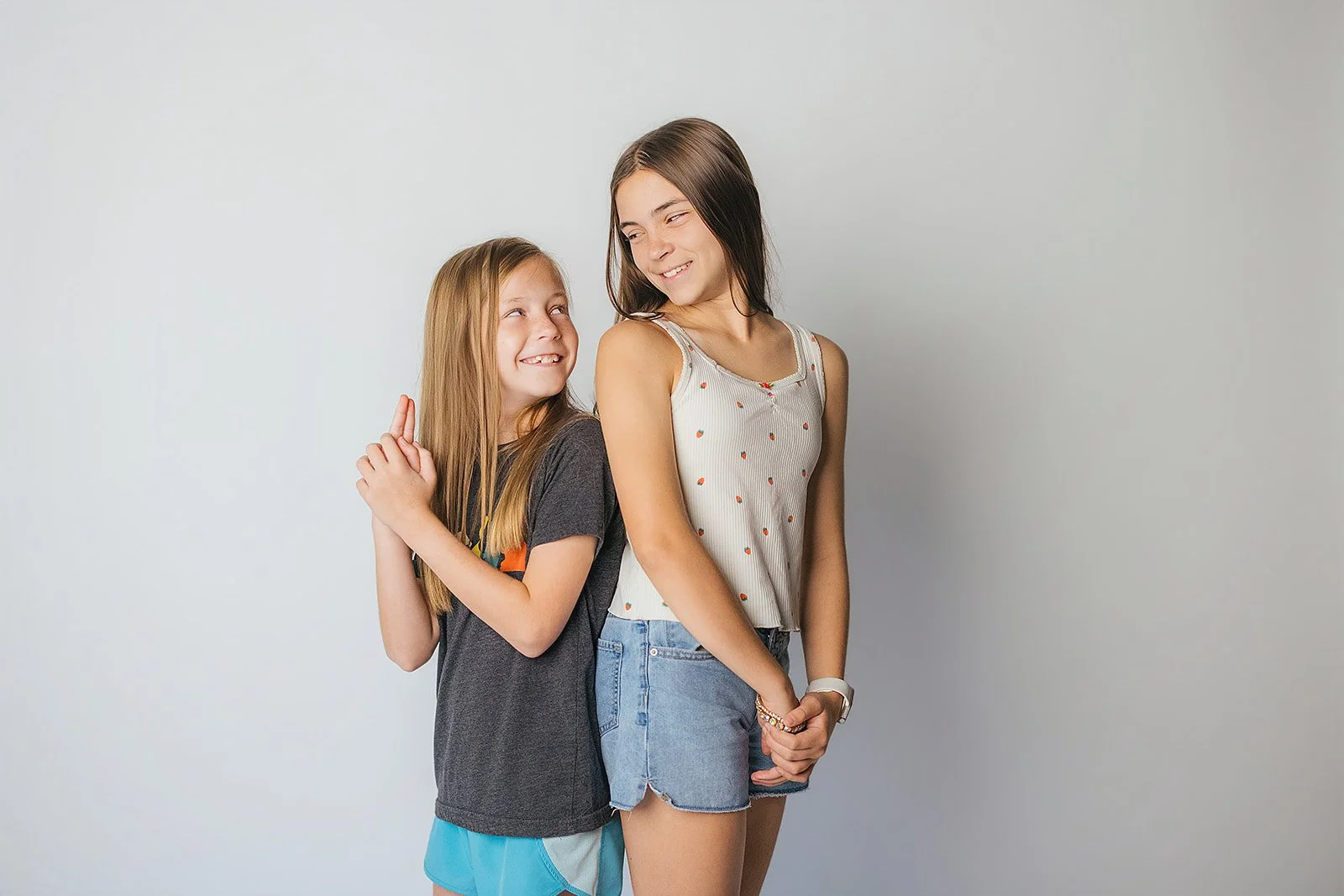 Sisters Standing Back to Back During Childhood Studio Portraits Durham NC