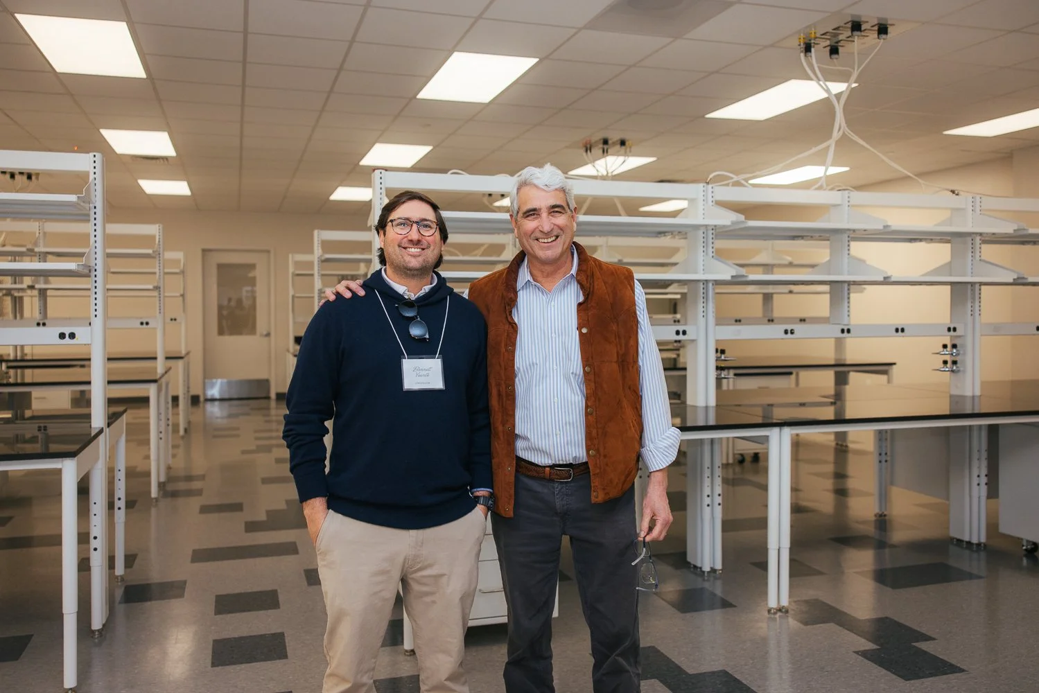 Two men posing together inside the Longfellow Triangle LIFE lab space in Raleigh NC during a corporate campus event