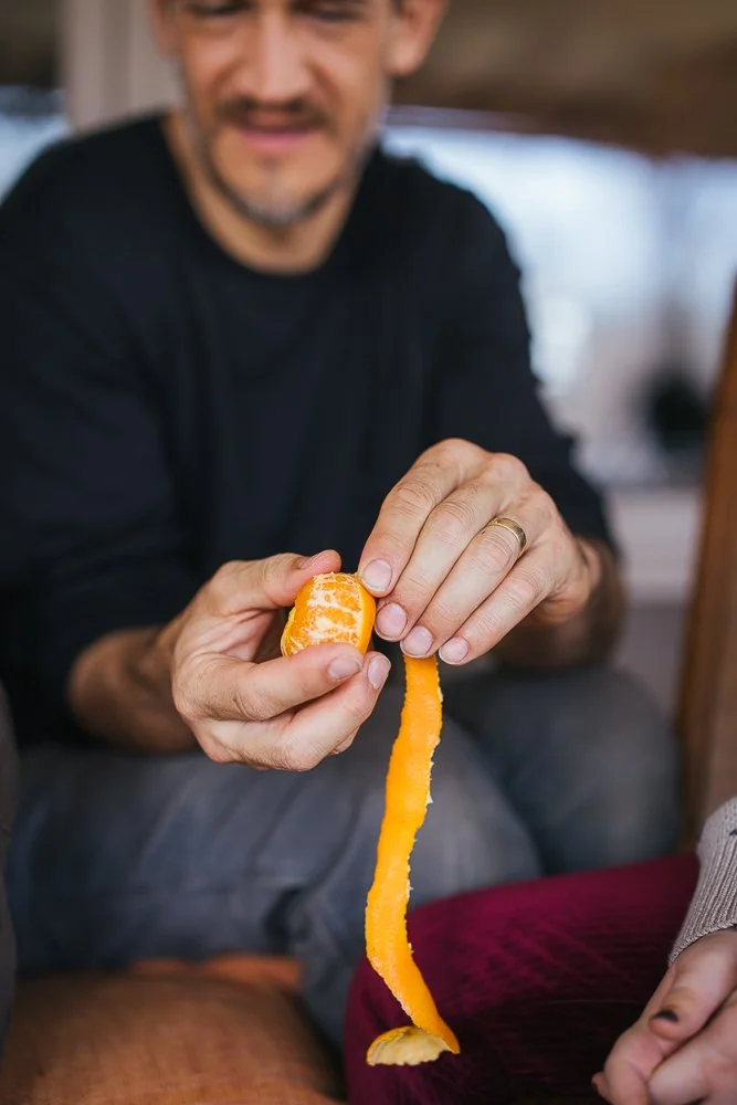 Person Peeling Orange During In-Home Family Photography Session