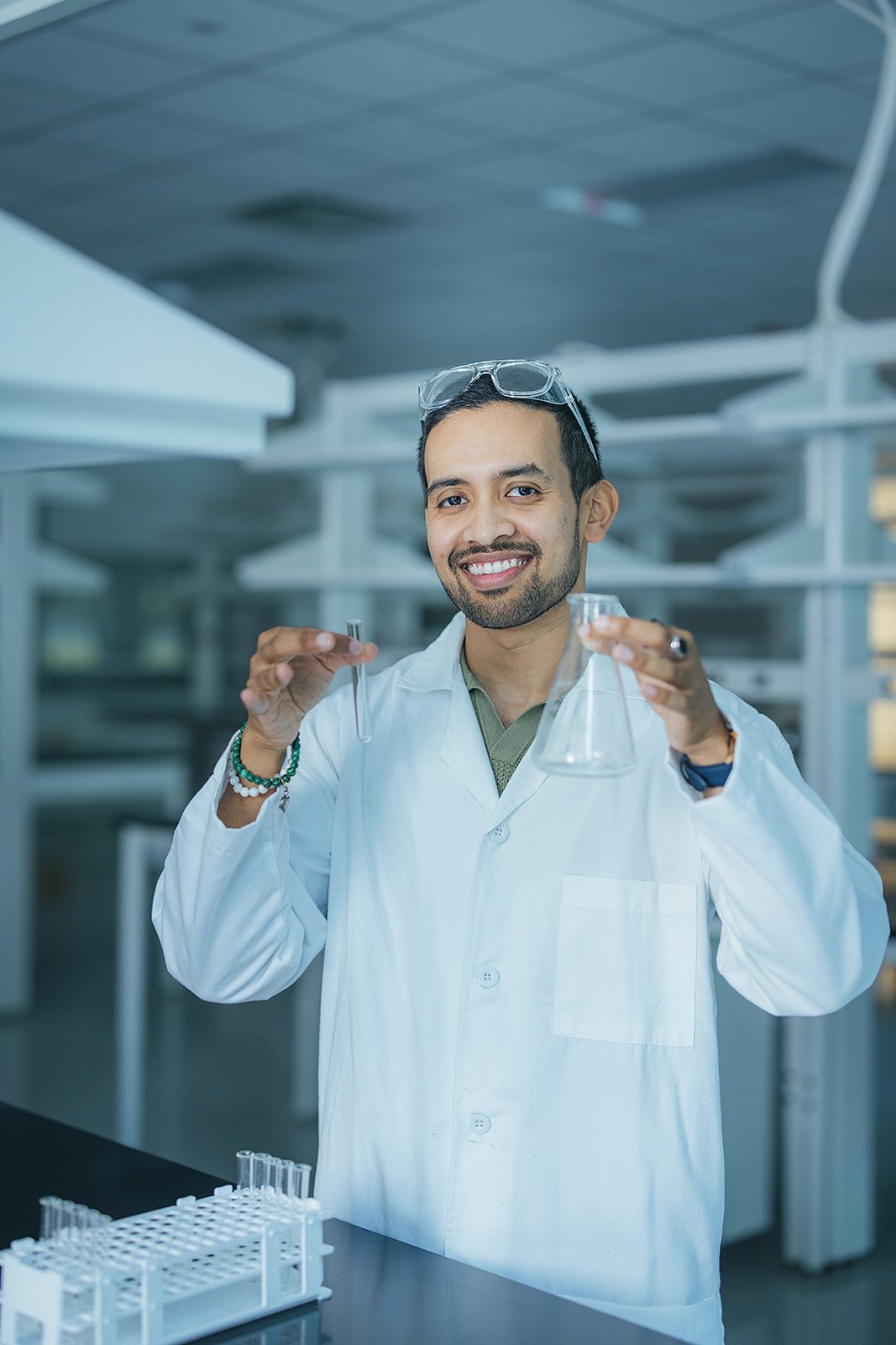 ManInLabCoatAndGogglesHoldingBeakers
