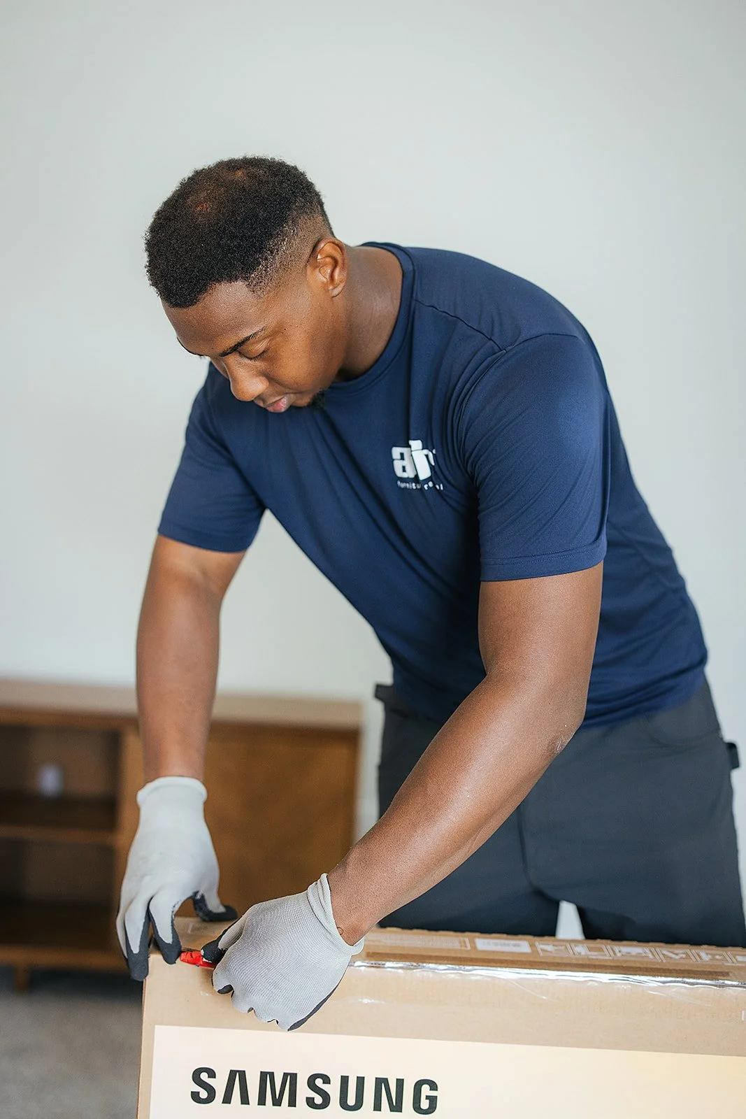 Behind-the-scenes photograph of AFR Furniture Rental arranging a living space in Durham, NC
