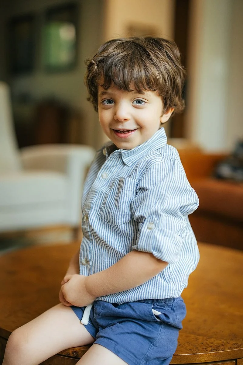 Young boy in button down shirt smiling for personal portrait