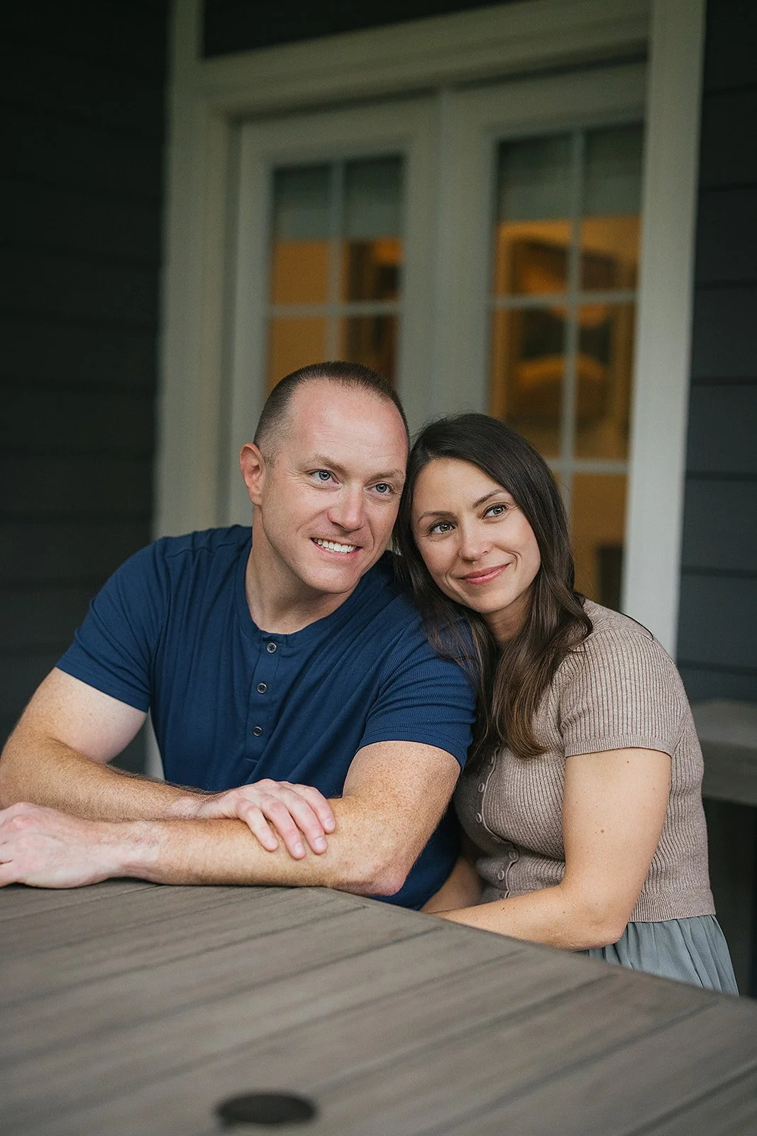 Husband and wife smiling on back porch Chapel Hill NC