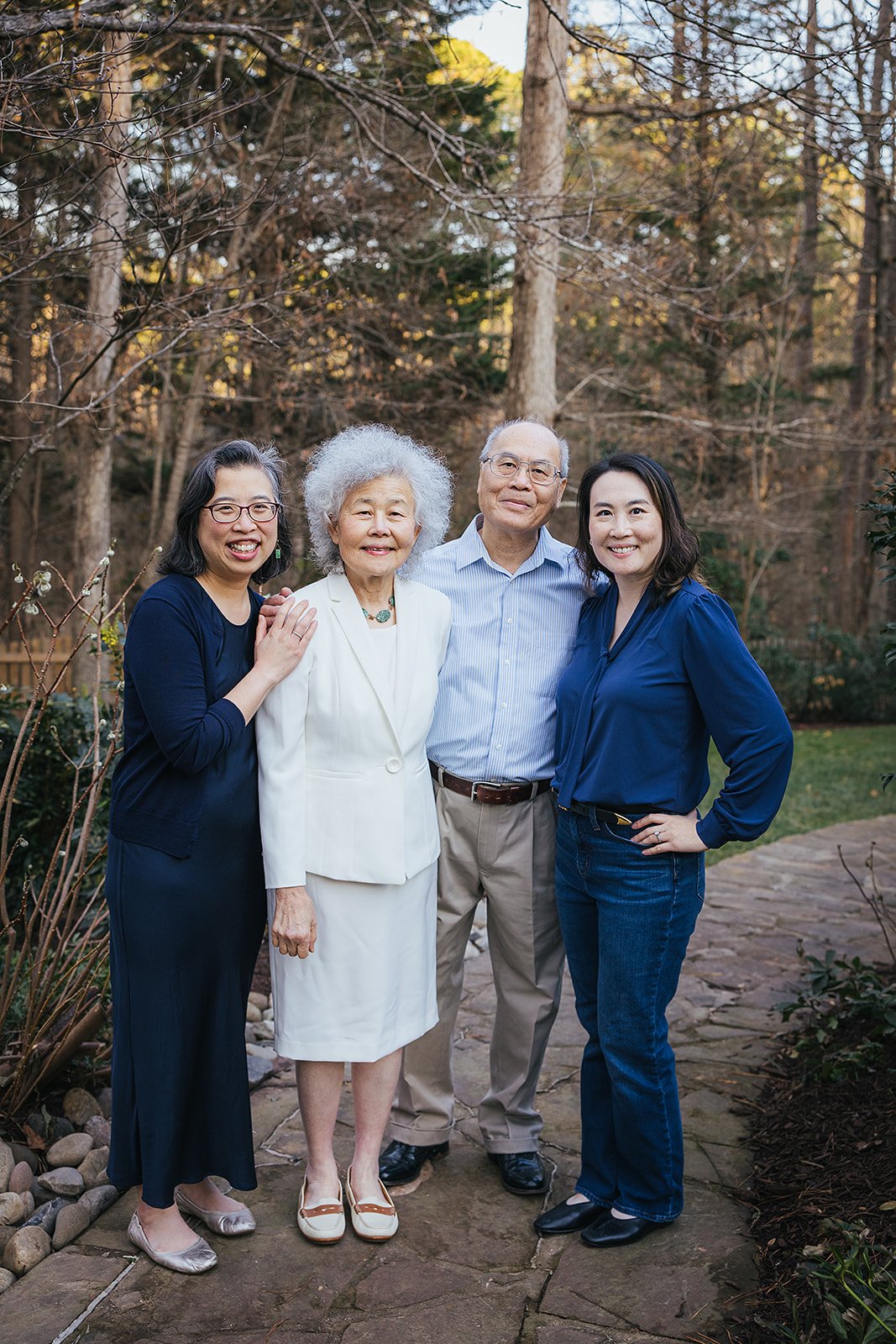 Grown daughters smiling with parents outside family home Durham NC