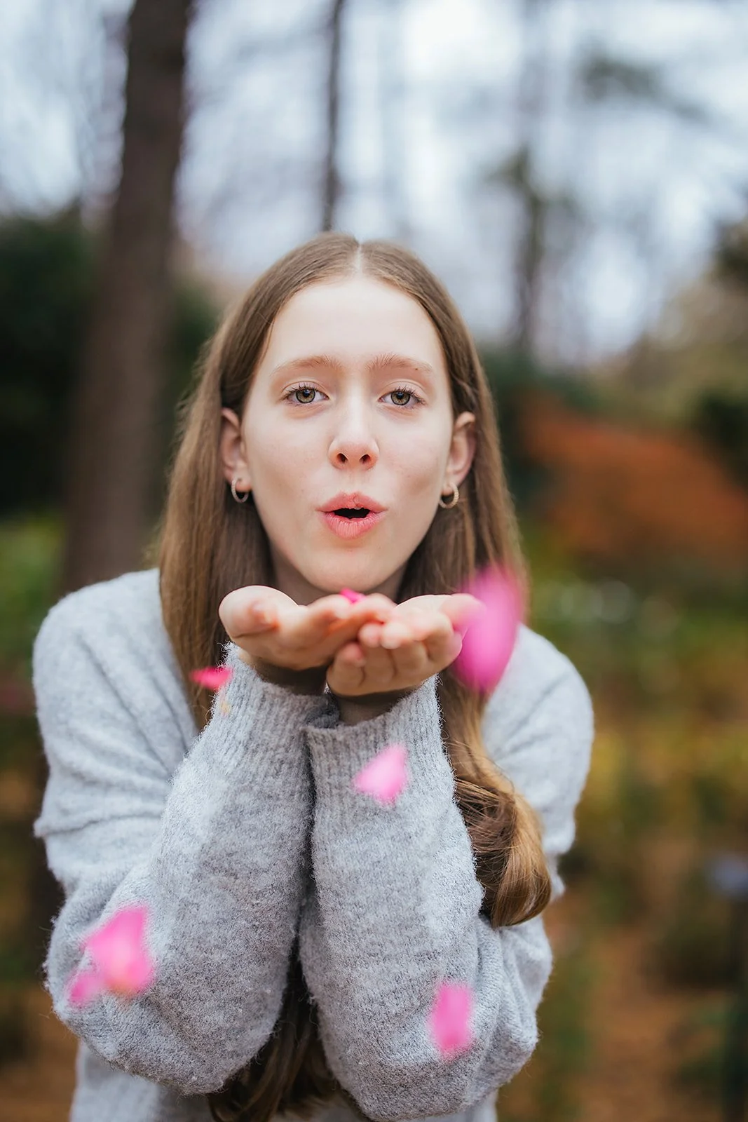 Young Girl Blowing Pink Flower Petals at WRAL Azalea Gardens