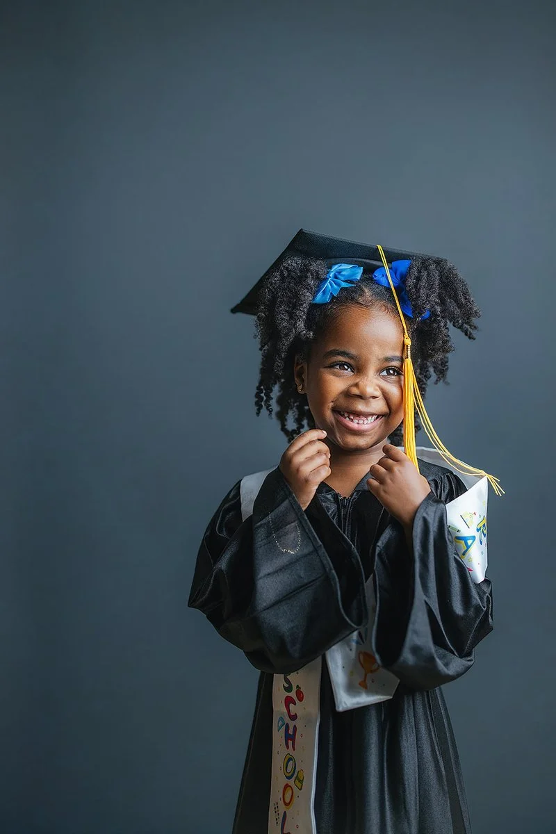 Young Girl Laughing While Wearing Graduation Gown