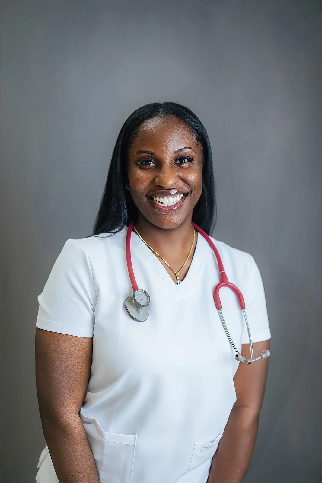 Durham Tech nursing student smiling in white scrubs and red stethoscope, professional headshot by Fifty Two Hundred Photography in Durham NC