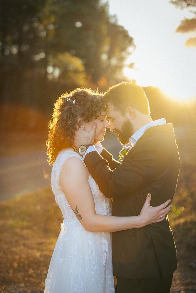 Bride and groom touching foreheads in a quiet intimate moment during golden hour portraits on the pine path at Honeysuckle Tea House Chapel Hill NC