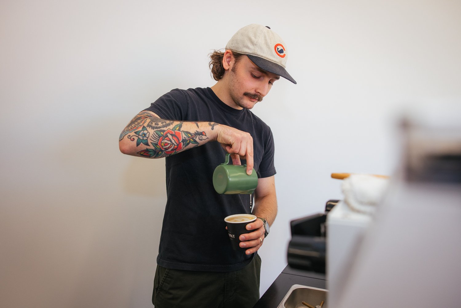 Barista pouring latte art at the coffee bar during a corporate event at Longfellow Triangle LIFE innovation campus in Raleigh NC