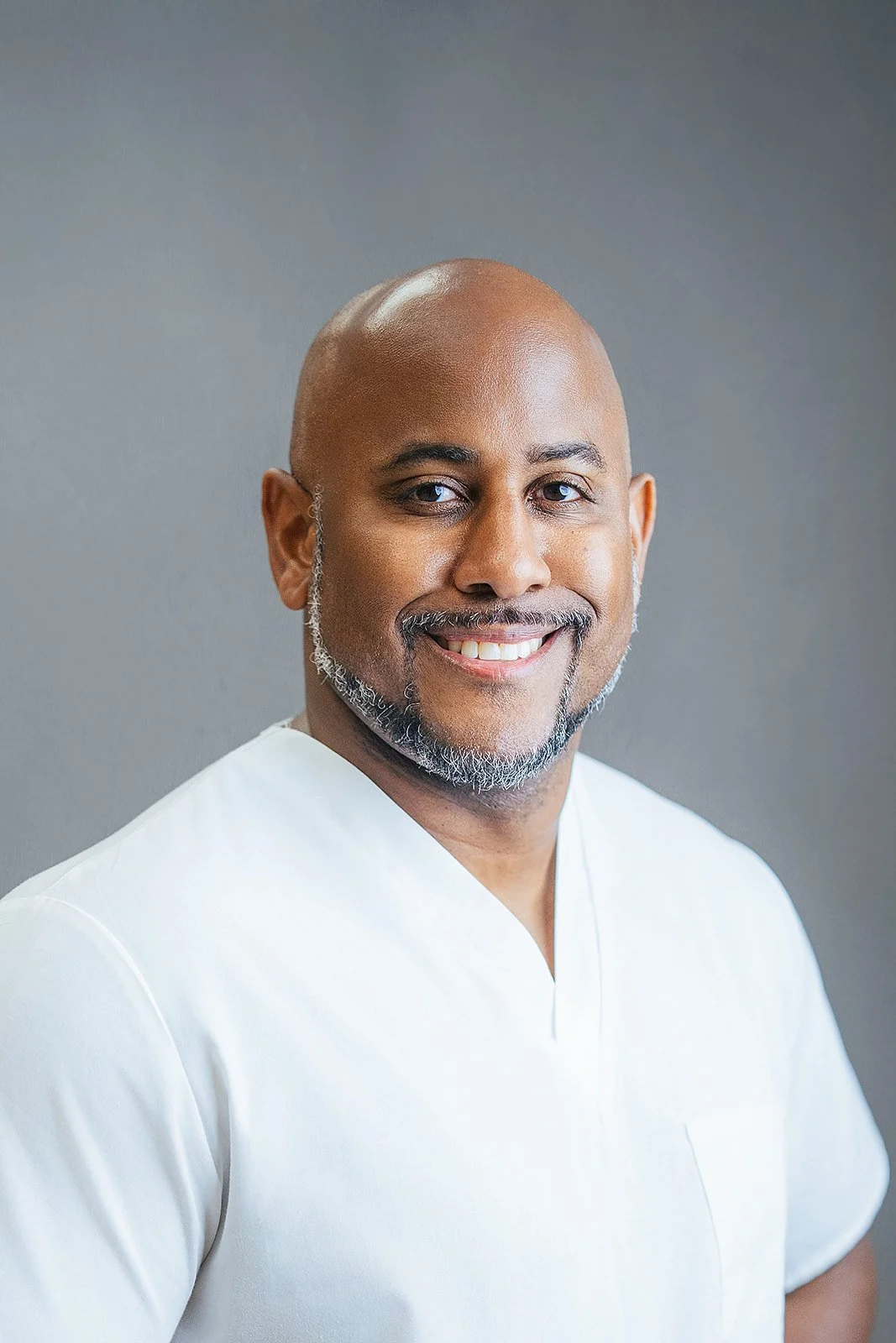 Durham Tech nursing student with warm confident smile in white scrubs, professional headshot by Fifty Two Hundred Photography in Durham NC
