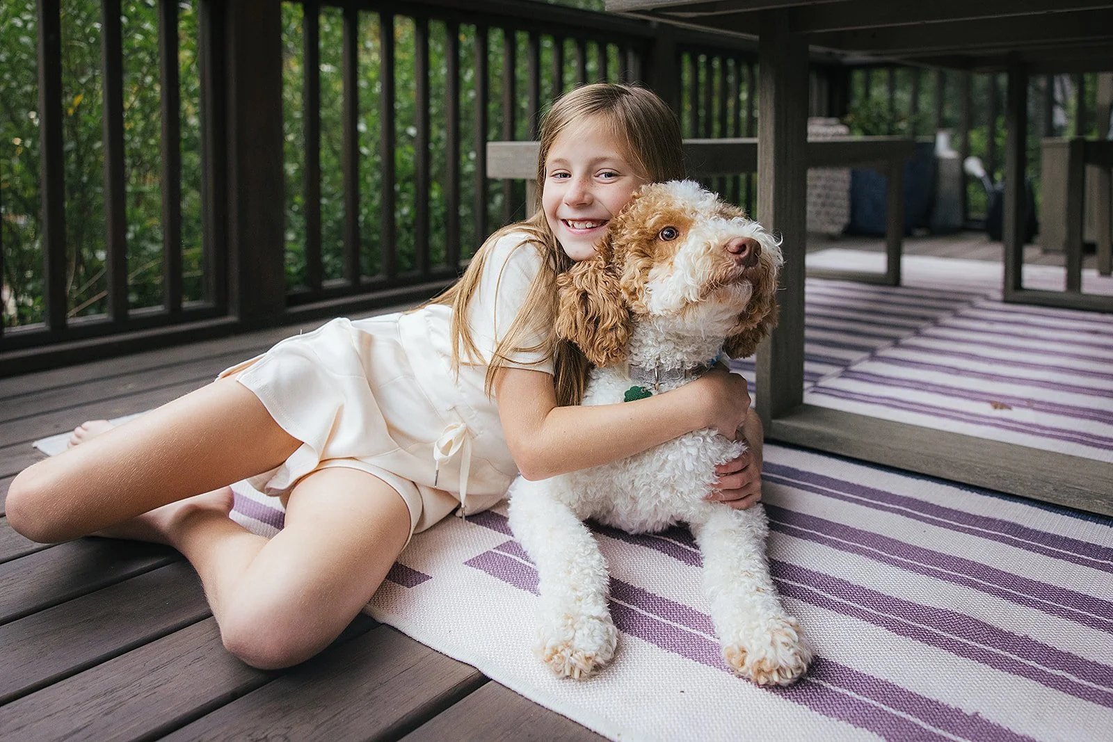 Young girl hugging dog on back deck Chapel Hill NC
