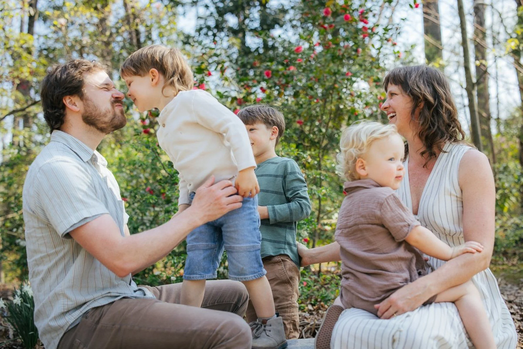 Family of five smiles together in neutral toned outfits for a family photography session