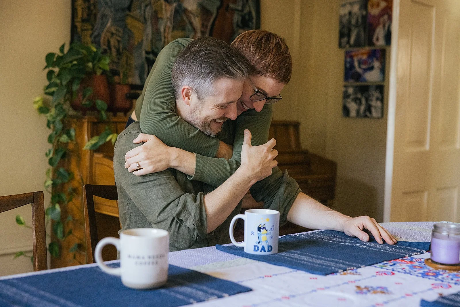 Mom and Dad Hugging and Smiling During In-Home Family Photo Session