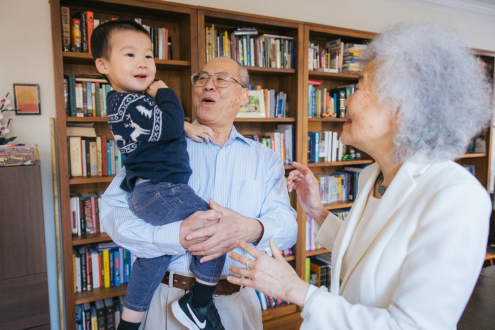 Grandparents laughing with grandchild inside family home in Durham NC