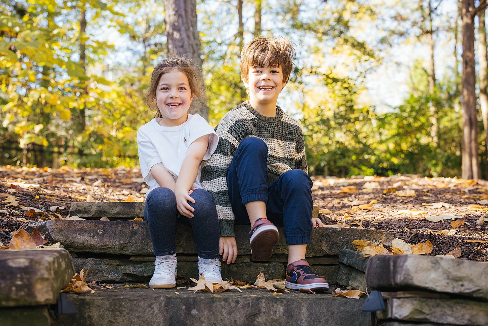 Two Young Siblings Smiling Outside in Backyard