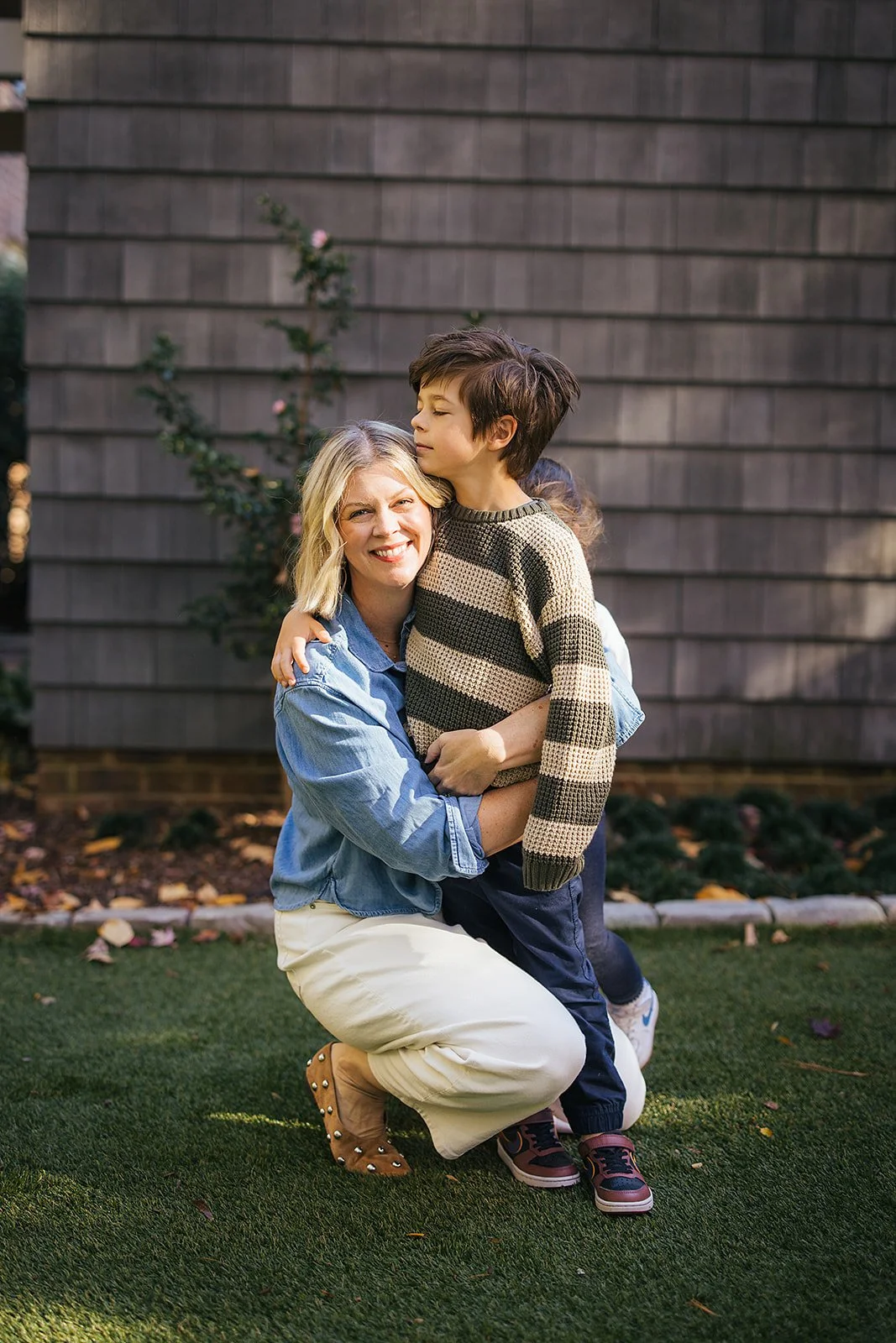 Mom Hugging Young Son Outside in Backyard