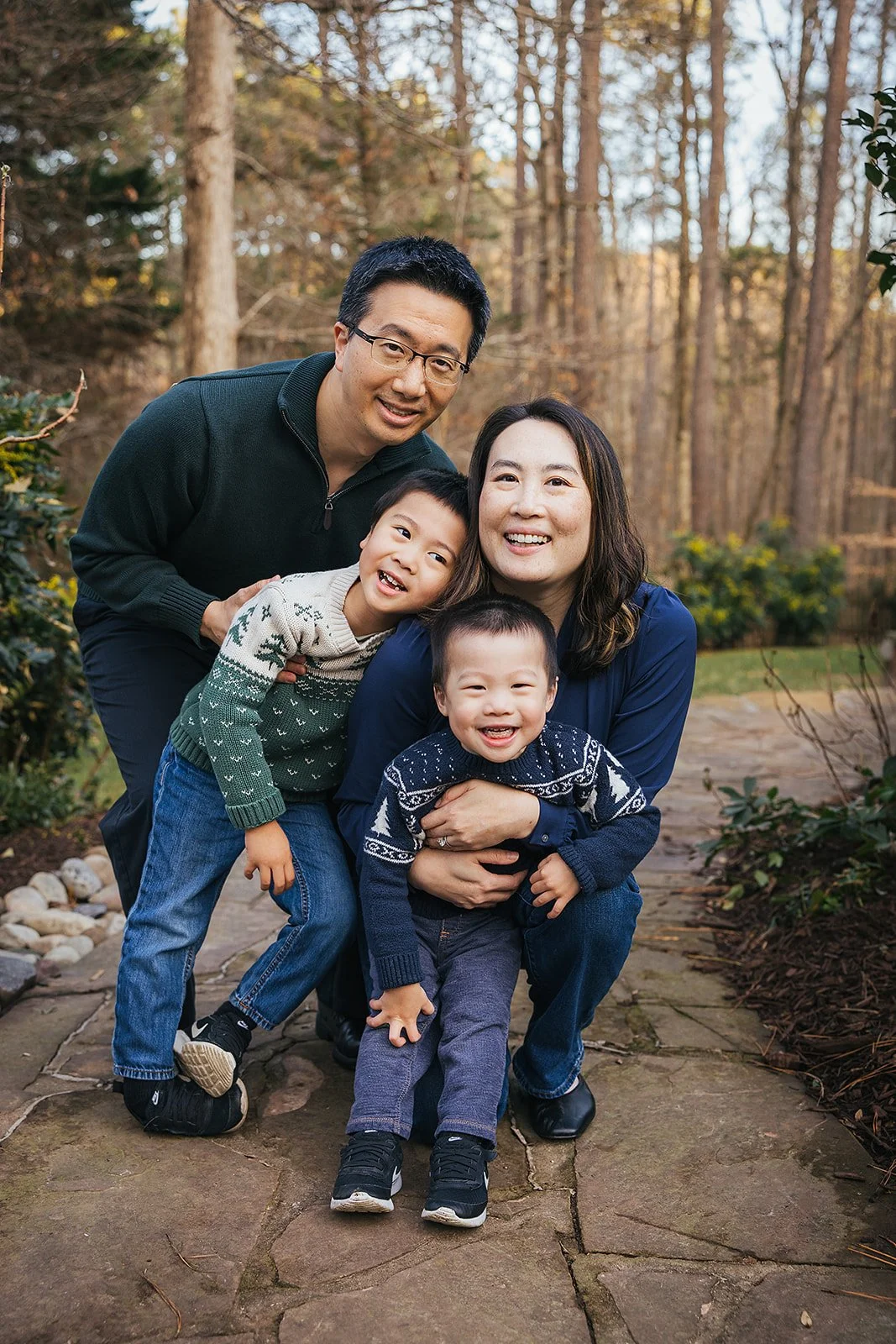 Family of four smiling outside family home