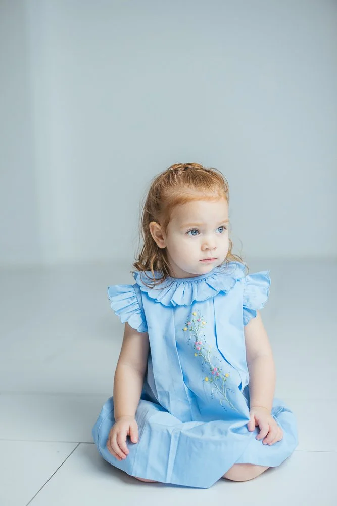 Girl in blue dress with red hair poses for a milestone session in Durham NC