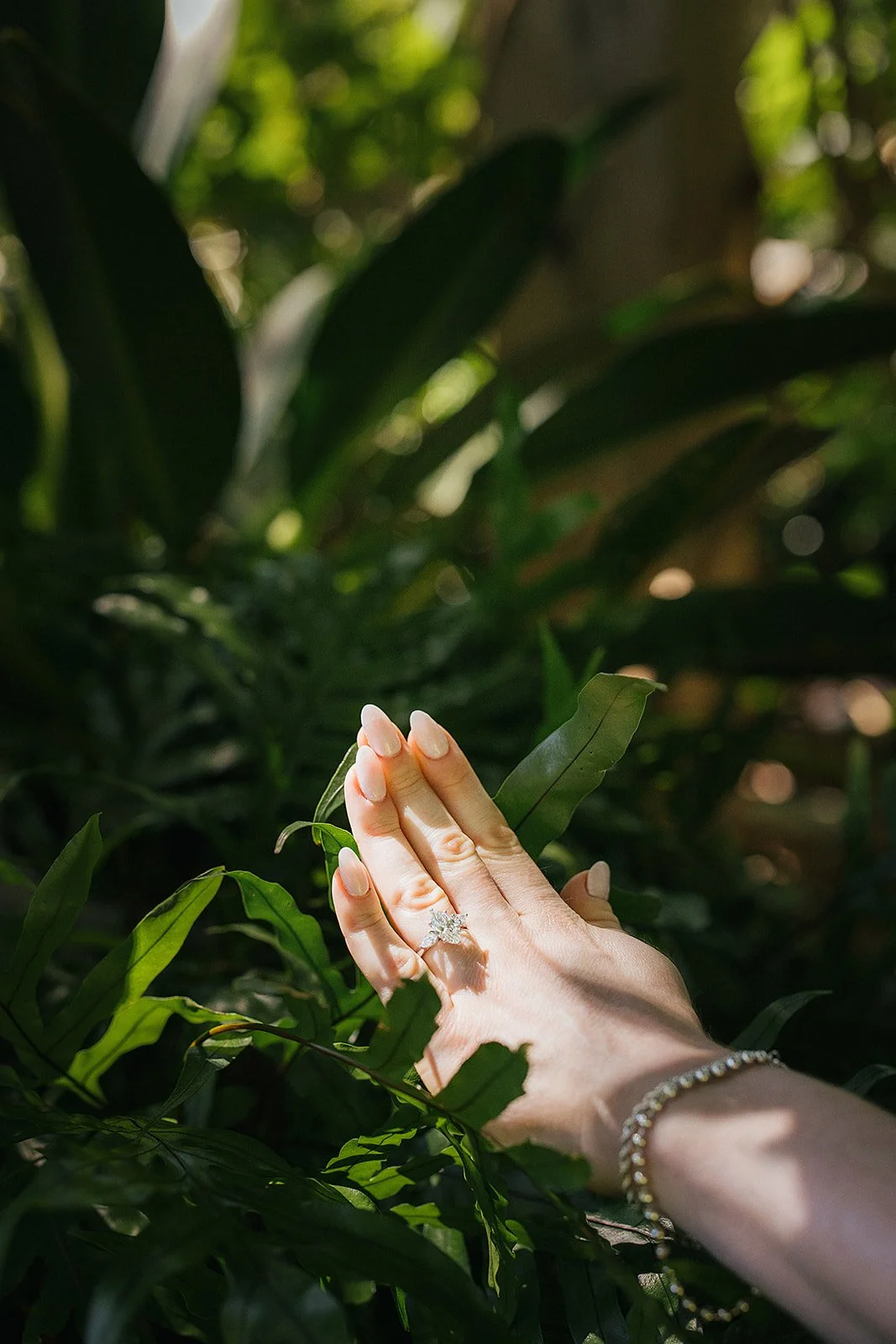 Womans hand showing off engagement ring during engagement photography session