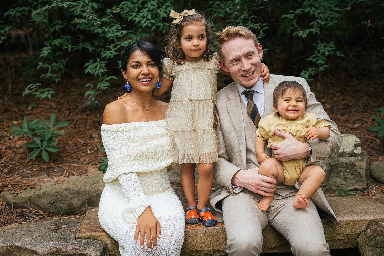 family of four smiles after a vow renewal ceremony at Duke Gardens in Durham, NC