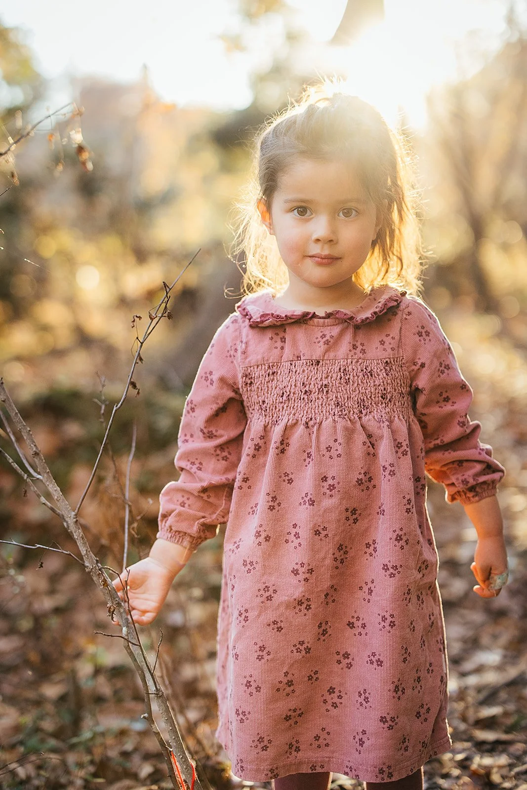 A child is backlit by the setting sun at a family photoshoot in Durham, NC