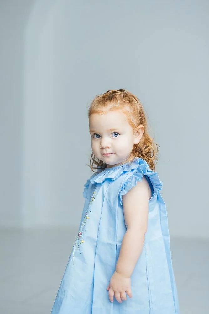 Beautiful young girl looks at the camera during a milestone child portrait studio photography session in Durham, NC
