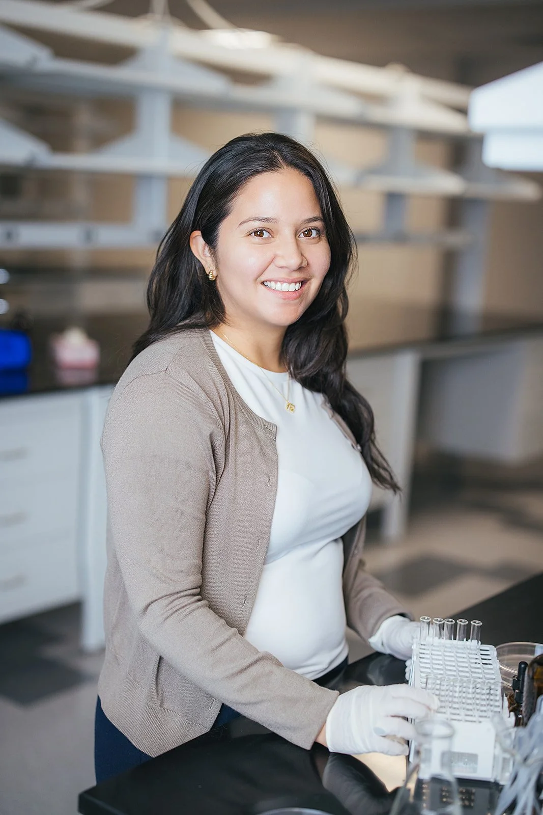 WomanInBrownSweaterWearingGlovesInLab